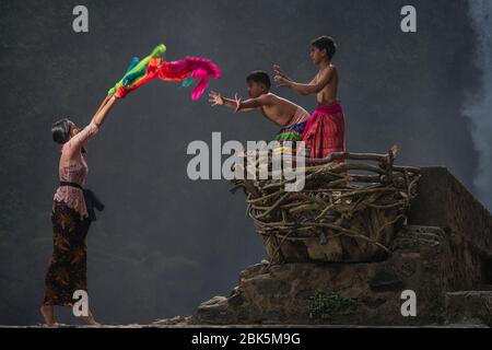 Blangsinga Waterfall, Blahbatuh, Gianyar, Bali, Indonesia - 29 giugno 2019 : sorella maggiore con i suoi fratelli più giovani che giocano alla cascata Blangsinga Foto Stock