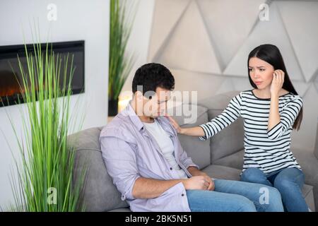 Giovane ragazzo di cattivo umore e moglie simpatica. Foto Stock