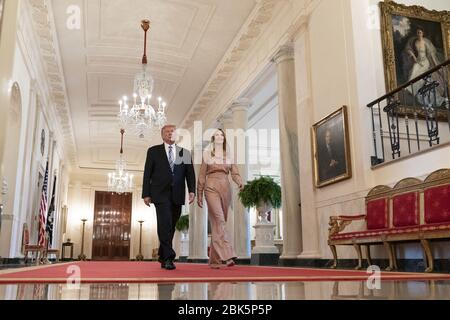 Washington, Stati Uniti d'America. 28 Aprile 2020. Il presidente Donald J. Trump e consigliere del presidente Ivanka Trump camminano lungo la Cross Hall della Casa Bianca Martedì, 28 aprile 2020, quando arrivano a partecipare a un evento nella East Room sul programma di protezione degli assegni e il suo sostegno alle piccole imprese durante la pandemia di coronavirus. Persone: Presidente Donald Trump, Ivanka Trump Credit: Storms Media Group/Alamy Live News Foto Stock