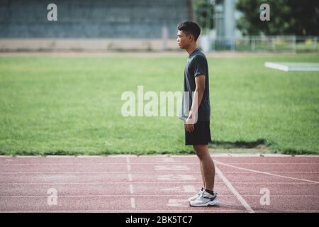 atleta in piedi su una pista da corsa per tutte le condizioni atmosferiche Foto Stock