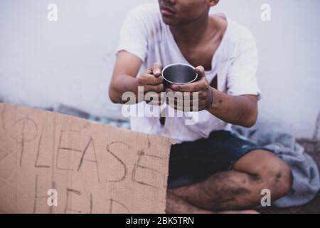 Il povero elemosina, l'uomo asiatico senza casa mendicando denaro Foto Stock
