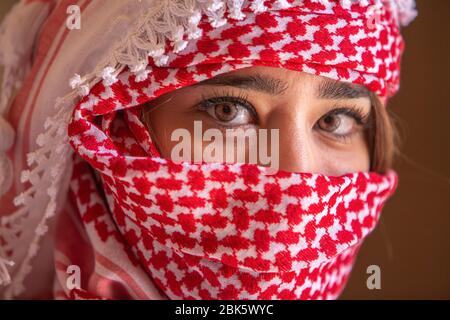 Giovane donna giordana con la tradizionale sciarpa con testa a keffiyeh a Jerash, Giordania Foto Stock