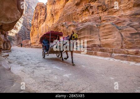 Carrozze trainate da cavalli nel Siq slot Canyon nella città di Petra, Giordania Foto Stock