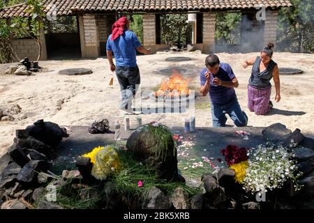 Sciamano che esegue una cerimonia di guarigione Maya per una famiglia sulla cima della collina Pascual Abaj, dove si trova la pietra sacra. Alcune fonti indicano Th Foto Stock