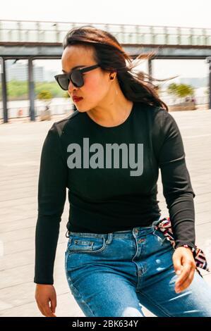 Una giovane donna cinese che pratica lo skateboard vicino al lungomare di fronte al Long Museum West Bund, Shanghai, Cina. Foto Stock