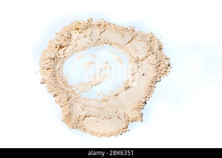 Polvere sbiancante minerale sfuso.polvere sfusa scatterizzata tan colorato viso su sfondo bianco. Foto Stock
