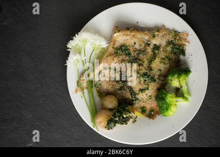 Un raggio, o skate, ala da un Thornback ray, Raja clavata, catturato nel canale inglese. E' stato fritto in olio e burro con aglio selvatico e mantello Foto Stock