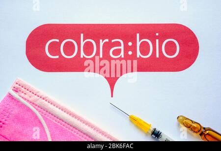 Stone / United Kingdom - 1 maggio 2020: Cobra : logo bio Company stampato come opuscolo con maschera chirurgica e siringa e mecicina in alto. Cobra Biologics Foto Stock