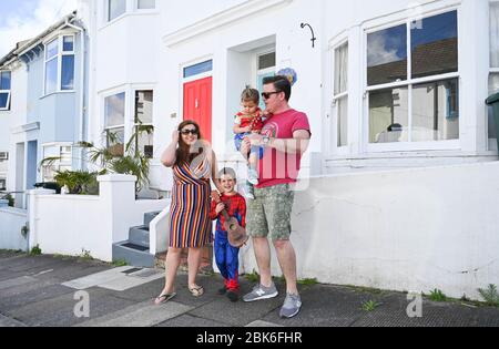 Brighton UK 2 maggio 2020 - i bambini delle famiglie nella zona di Elm Grove di Brighton hanno deciso di vestirsi e brevemente venire fuori sulla loro strada questa mattina osservando le distanze sociali il giorno che sarebbe stato il festival di Brighton Parade dei bambini durante la pandemia di Coronavirus COVID-19 crisi . La Parata dei Bambini è il tradizionale apritore del Festival di Brighton che è stato annullato quest'anno a causa del coronavirus . Credit: Simon Dack / Alamy Live News Foto Stock