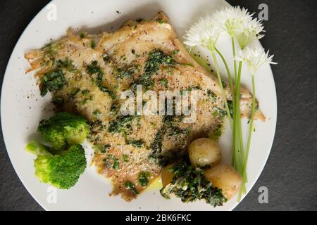 Un raggio, o skate, ala da un Thornback ray, Raja clavata, catturato nel canale inglese. E' stato fritto in olio e burro con aglio selvatico e mantello Foto Stock