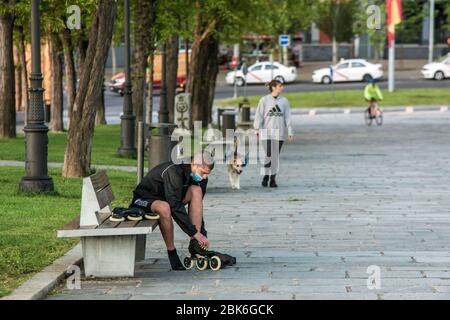 Madrid, Spagna. 02 maggio 2020. Un uomo che indossa una maschera facciale come precauzione mette su pattini a rotelle mentre siede su una panchina lungo il parco durante le 5 fasi di lasciare il confinamento in mezzo a Coronavirus.After 49 giorni di blocco, il governo spagnolo inizia la prima delle 5 fasi di lasciare il confinamento. Consente un'ora di esercizio individuale per gli adulti in due fusi orari, uno dalle 6:00 alle 10:00 e l'altro dalle 20:00 alle 23:00. Credit: SOPA Images Limited/Alamy Live News Foto Stock