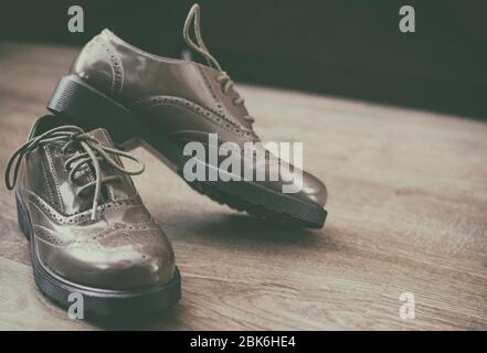 Le scarpe Oxfords sono in stile retrò e si trovano sul pavimento in legno Foto Stock