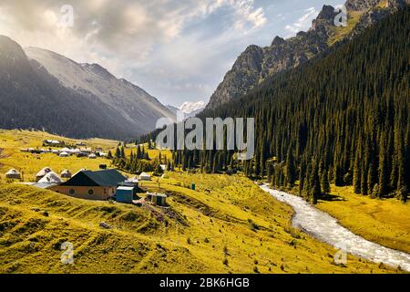 Fiume Arashan e pensioni con yurt nella valle di montagna di Altyn Arashan Gorge, il Kirghizistan Foto Stock