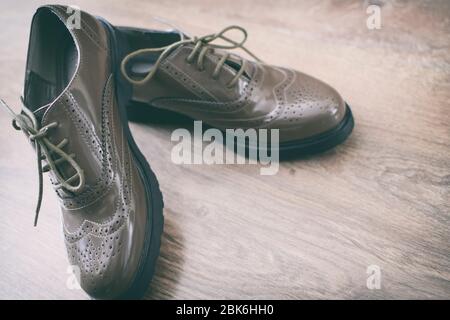 Le scarpe Oxfords sono in stile retrò e si trovano sul pavimento in legno Foto Stock