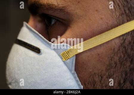 Dettagli viso ragazzo mentre vestire la maschera protettiva del virus corona covid-19, malattia Foto Stock