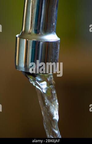 acqua che fuoriesce da un rubinetto Foto Stock