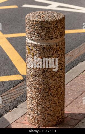 una vista ravvicinata di un palo in cemento che viene posizionato per impedire l'ingresso di auto, camion e veicoli pesanti Foto Stock