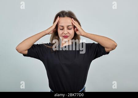 Ragazza stanca con dolore e impotenza che tiene la sua testa con le mani Foto Stock