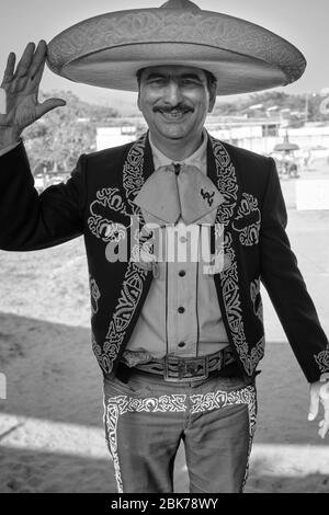 Ritratto di un cowboy messicano vestito il modo tradizionale salutando con un sorriso. Foto Stock