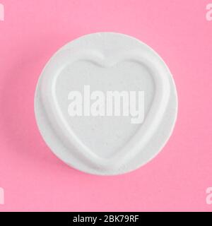 Un solo Amore cuori dolce o caramella in una cornice quadrata e uno sfondo rosa con spazio per copia Foto Stock