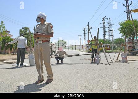 Beawar, India. 1 maggio 2020. Un personale di polizia che indossa la maschera protettiva per il viso stare in piedi vicino a una barricata al cancello di ingresso nella zona del consiglio di alloggiamento, dove tre COVID-19 paziente positivo è stato trovato durante il governo ha imposto blocco a livello nazionale in seguito alla pandemia di coronavirus, a Beawar, India il 1 maggio 2020. (Foto di Sumit Saraswat/Pacific Press/Sipa USA) Credit: Sipa USA/Alamy Live News Foto Stock