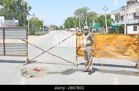 Beawar, India. 1 maggio 2020. Un personale di polizia che indossa la maschera protettiva per il viso stare in piedi vicino a una barricata al cancello di ingresso nella zona del consiglio di alloggiamento, dove tre COVID-19 paziente positivo è stato trovato durante il governo ha imposto blocco a livello nazionale in seguito alla pandemia di coronavirus, a Beawar, India il 1 maggio 2020. (Foto di Sumit Saraswat/Pacific Press/Sipa USA) Credit: Sipa USA/Alamy Live News Foto Stock