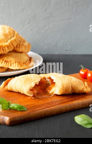 Calzone Panzerotti italiano fritto in casa con salsa, vista laterale. Spazio di copia. Foto Stock