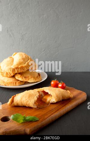 Calzone Panzerotti italiano fritto in casa con salsa, vista laterale. Spazio per il testo. Foto Stock