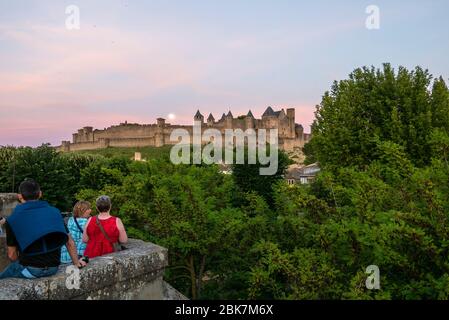 Turisti che guardano il castello medievale Chateau Comtal dal Pont Vieux a Carcassonne, Francia, Europa Foto Stock
