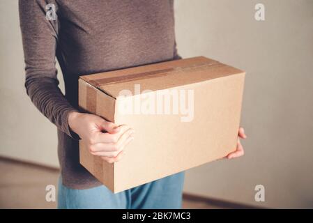 Le mani delle donne tengono la scatola con l'ordine consegnato. Foto Stock