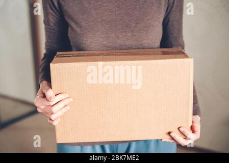 Le mani delle donne tengono la scatola con l'ordine consegnato. Foto Stock