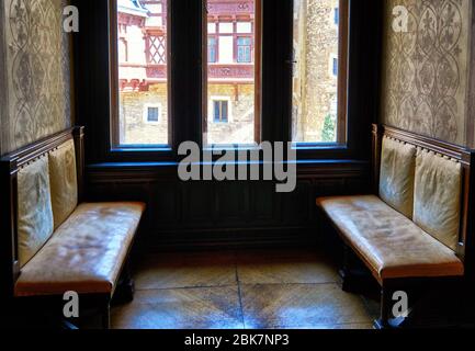 Vecchi panche in legno e pelle vicino alla finestra. Castello di Wernigerode in Germania. Foto Stock