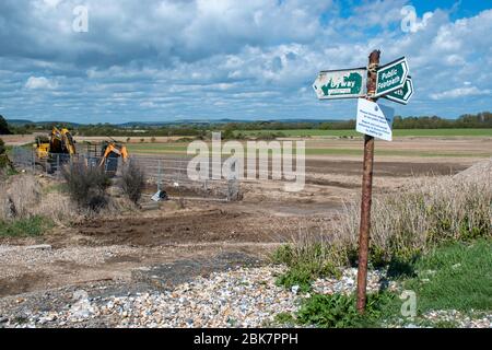 Climping, West Sussex, UK, 02 maggio 2020, segnale del sentiero pubblico colpito dagli elementi con una bella vista della campagna del sussex occidentale. Foto Stock