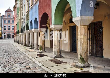 Una serie di colonne in pietra nelle arcate di case storiche affittate sulla piazza del mercato di Poznan Foto Stock