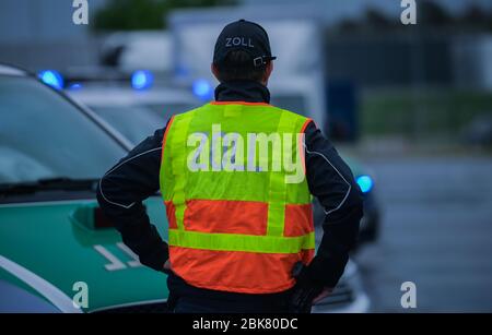 30 aprile 2020, Hessen, Francoforte sul meno: Un funzionario doganale si trova accanto al suo veicolo durante un'ispezione di un camion all'aeroporto. Foto: Andreas Arnold/dpa Foto Stock