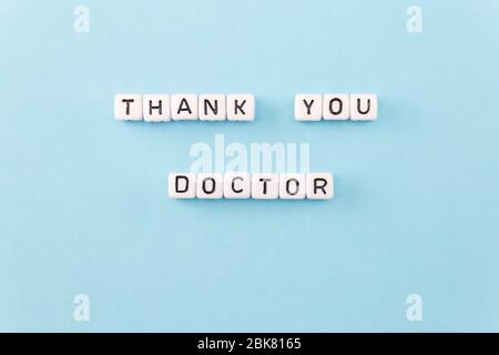 Grazie Phrase medico composto con cubi su sfondo blu Foto Stock
