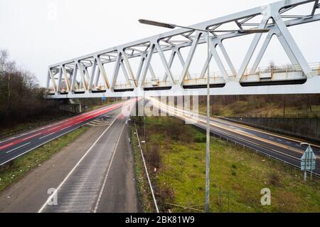 Ponte ferroviario in metallo alla M60 svincolo 25 j25 al crepuscolo sentieri autostrada inglese auto strada di viaggio Foto Stock