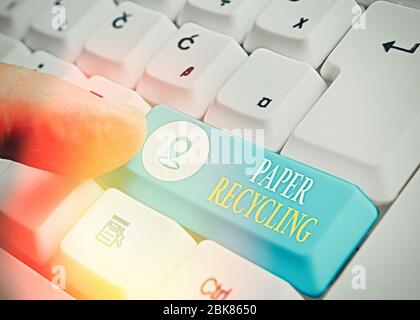 Scrittura concettuale della mano che mostra il riciclaggio della carta. Concetto che significa utilizzare i rifiuti in un nuovo modo riciclandoli Foto Stock