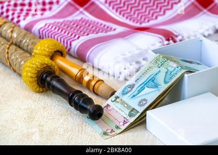 Set primo piano di sciarpa araba con keffiyeh o kafiya, igal o AGAL, banconote arabe UAE Dirhams e accessori Hookah. Foto Stock