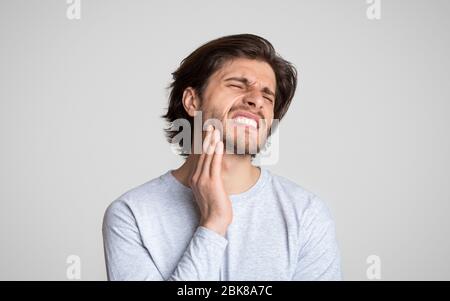 L'uomo sente dolore alla mandibola. Salute e cura dentale Foto Stock