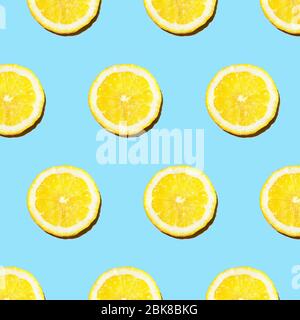Luce del sole alla moda modello estivo con fetta di limone giallo su sfondo blu chiaro. Concetto estivo minimo. Foto Stock