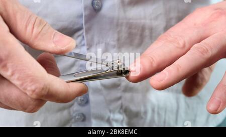 Taglio di unghie su una mano di uomo con le pinze per unghie. Primo piano. Foto Stock