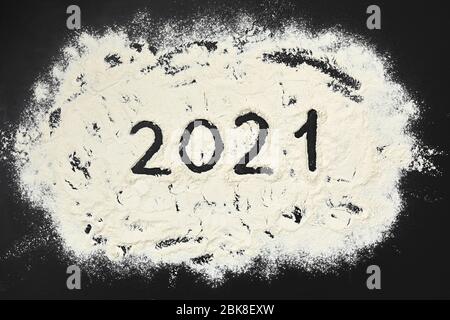 Numero 2021 testo con farina su fondo di legno nero. Vista dall'alto Foto Stock