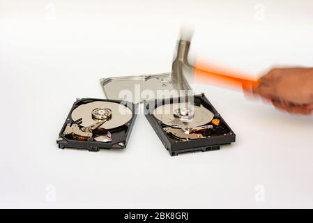 Distruggi il disco rigido con martello, concetto di sicurezza, effetto di sfocatura del movimento. Foto Stock