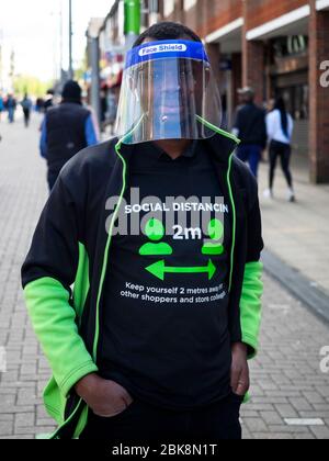 Walthamstow. Londra. REGNO UNITO. 2 maggio 2020. Primo piano di Essential Worker con visiera protettiva e maglietta a distanza sociale. Questo tipo lavora in Asda Superm Foto Stock