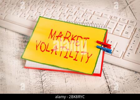 Nota scritta che mostra la volatilità del mercato. Concetto di business per i valori mobiliari sottostanti fluttuano lo stato di stabilità notebook promemoria clothespin WIT Foto Stock