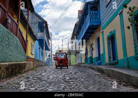 Giro in risciò rosso sulle strade acciottolate della vecchia zona di ​​Flores. Foto Stock