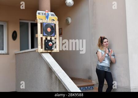 Vendrell, Spagna. 02 maggio 2020. Una donna sulla terrazza della sua casa applaudi durante gli anni '80 spettacolo musicale per incoraggiare i loro vicini durante il confino.Residents del quartiere Mas d'en Gual eseguire e applausi alle 8 pm per rallegrare i loro vicini durante il confinamento in mezzo alla crisi coronavirus. Questa volta hanno scelto il tema della Musica degli anni '80, un'intera mostra dove hanno potuto vedere le ragazze artisti vestiti come ABBA e un po 'di Freddy Mercury. Credit: SOPA Images Limited/Alamy Live News Foto Stock