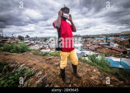 Nairobi, Kenya. 27 aprile 2020. Un uomo mette sulla sua maschera facciale come precauzione durante la vita di virus della corona pandemic.Daily in Kibera slums il più grande a Nairobi, non è stato molto influenzato dalla pandemia covid19 in corso, tranne per alcune attività limitate dal coprifuoco imposto a causa della pandemia. Credit: Donwilson Odhiambo/SOPA Images/ZUMA Wire/Alamy Live News Foto Stock