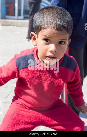 Essaouira, Marocco - Febbraio 25 2019: Ragazzo di tre anni per le strade di Essaouira, villaggio di pescatori, vendita di tessuti a Tourist. Foto Stock